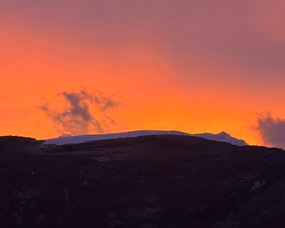 Sunrise over the glacier of the Sierra Nevada del Cocuy, orange sky behind the snow-covered ridge