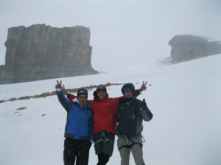 The two brothers and their cousin Juan Blanco on the glacier, with the Púlpito del Diablo behind, in the years when climbing onto the snow was permitted